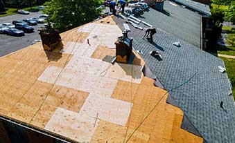 Expert team performing roof replacement on a residential property