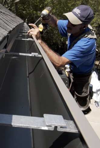 Technician measuring for custom gutter installation